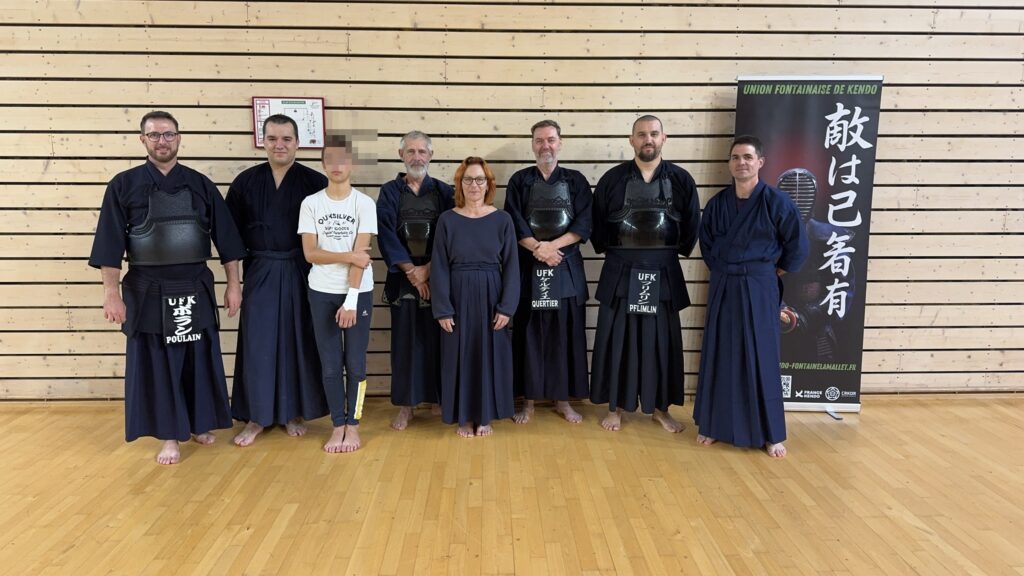 Groupe de pratiquants de l'Union Fontainaise Kendo en armure devant la bannière du club